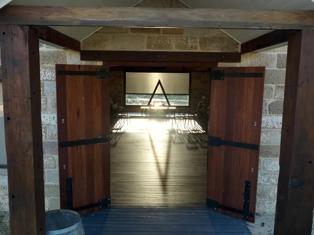Open timber doors of the chapel, with light glowing inside