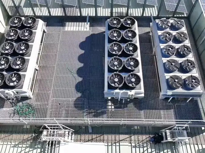 A commercial rooftop from the air: a condenser deck, the same plant in thermal, and a large solar array across the roof